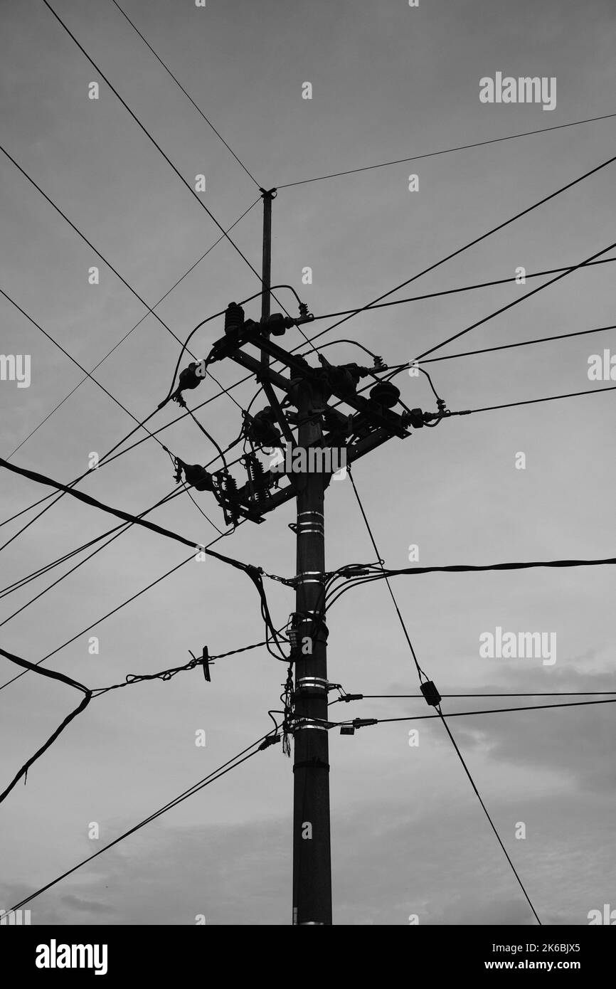 Monochromes Foto, ein mit unordentlichen Drähten gefüllter elektrischer Pol im Gebiet von Cikancung - Indonesien Stockfoto
