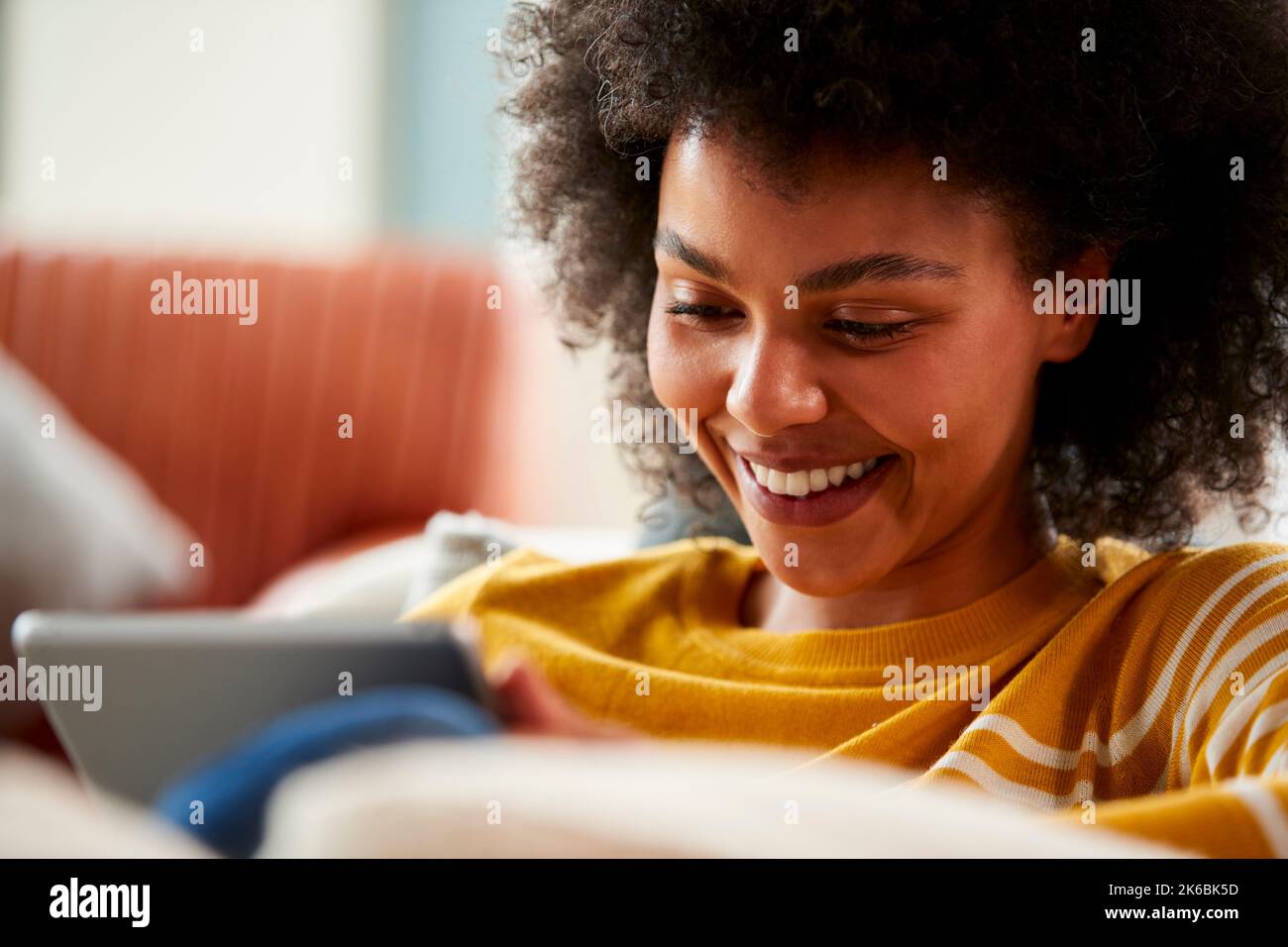 Frau, Die Sich Zu Hause Auf Dem Sofa Entspannt, Mit Einem Digitalen Tablet, Um Filme Zu Streamen Oder Online Einzukaufen Stockfoto