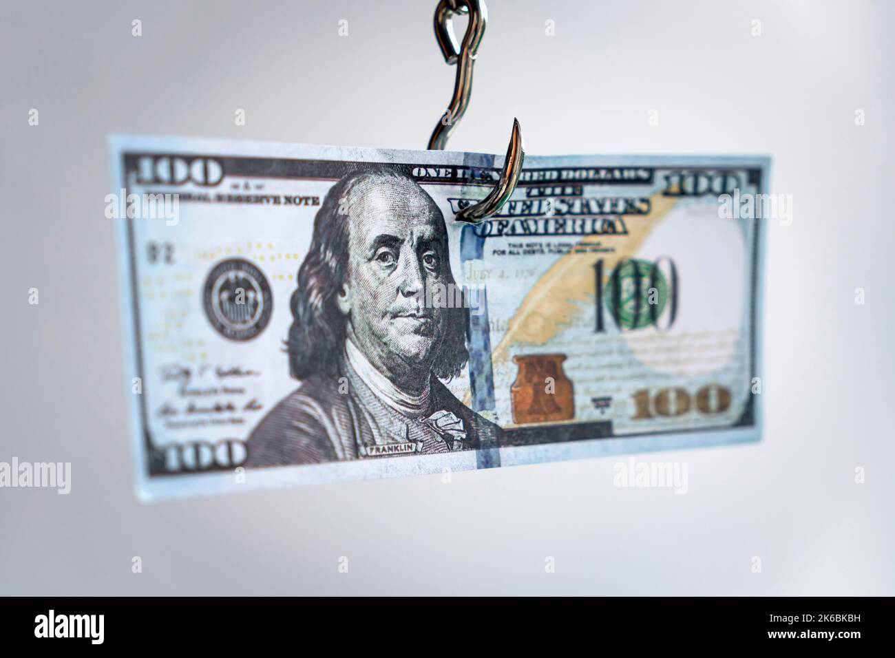 Geld auf dem Haken. Süchtig nach Dollar Idee kreative Foto. Finanzkonzept für Kredite oder eine andere Geldfalle. Abhängigkeit vom Dollar-Konzept Stockfoto