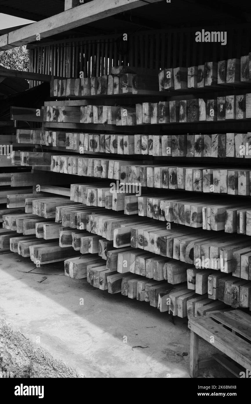 Monochromes Foto, ordentlicher Stapel von Holzblöcken in einem Lagerhaus in der Cikancung-Gegend - Indonesien Stockfoto