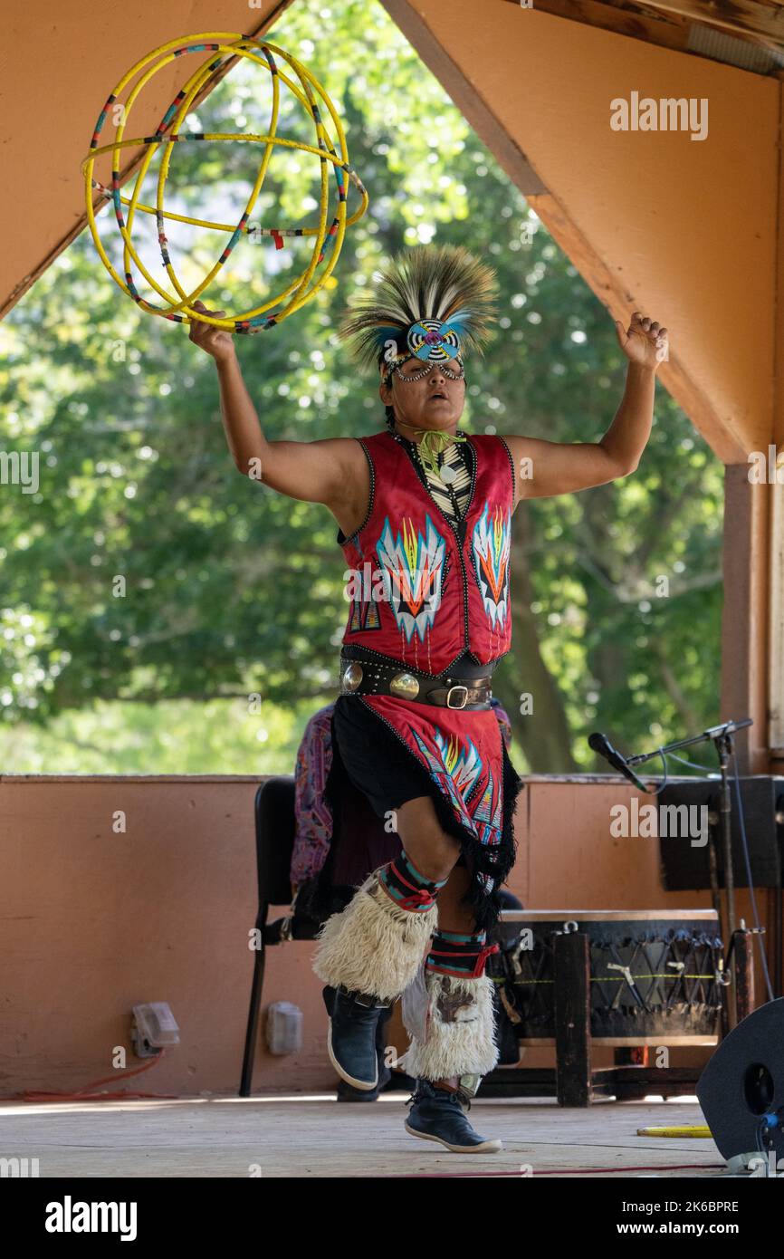Navajo Native American Hoop Dancer in Regalia, die auf einem Festival in Moab, Utah, auftreten. Dahinter ç ein Schlagzeuger des Sängers. Stockfoto
