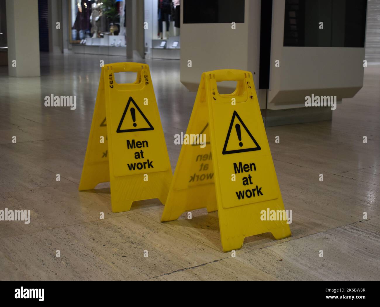 Gelbe „Men at Work“-Schilder im Einkaufszentrum Milton Keynes. Stockfoto