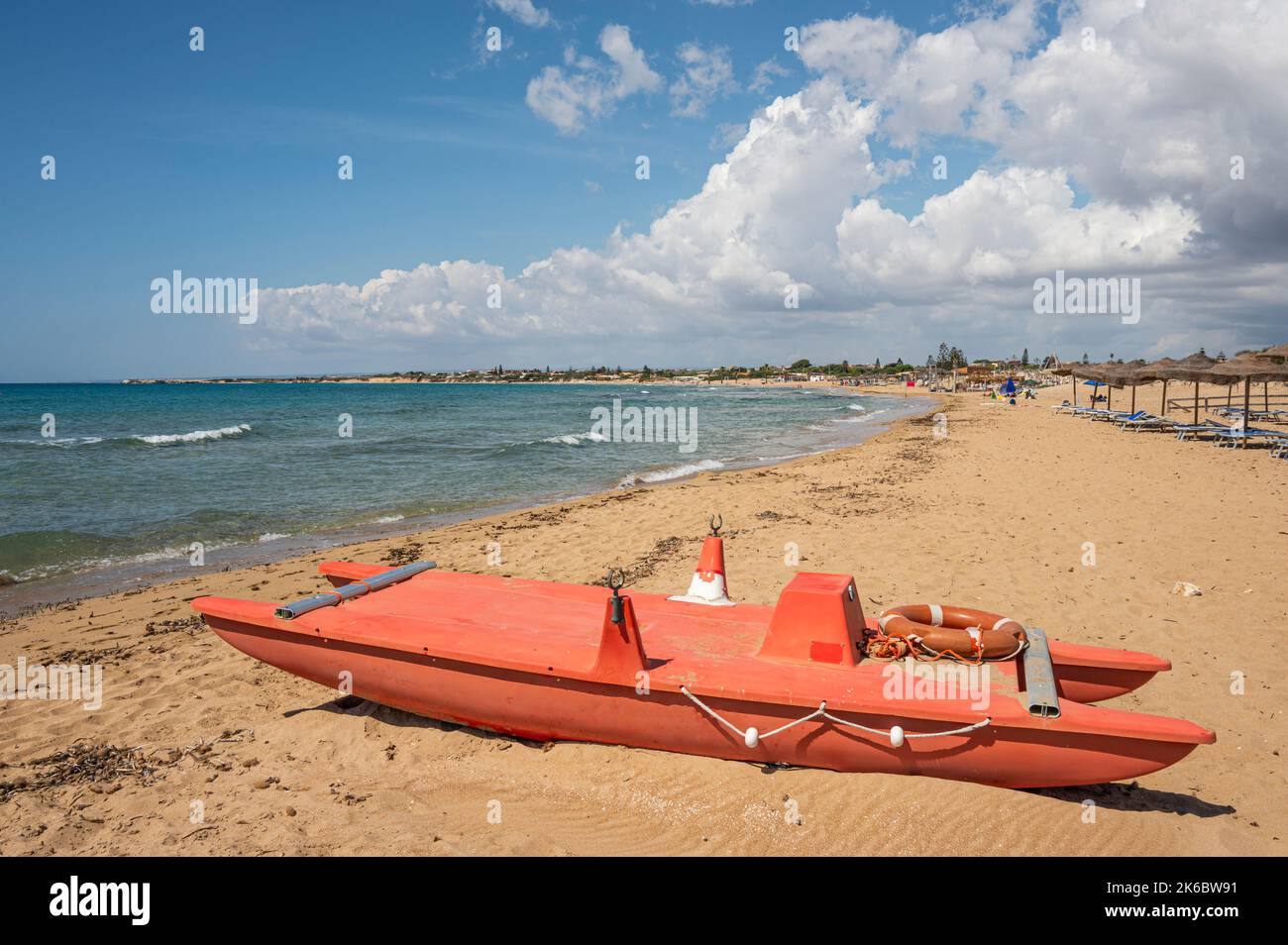 Portopalo, Italien - 09-17-2022: Schöner Strand mit Sand, türkisfarbenem und grünem Wasser ist ein roter Patino im Vordergrund in Portopalo di Capo Passero Stockfoto