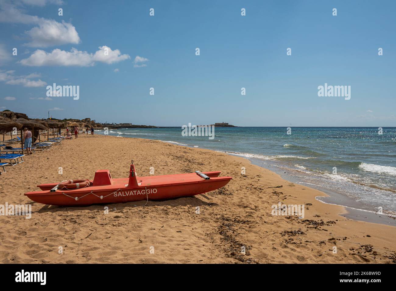 Portopalo, Italien - 09-17-2022: Schöner Strand mit Sand, türkisfarbenem und grünem Wasser ist ein roter Patino im Vordergrund in Portopalo di Capo Passero Stockfoto