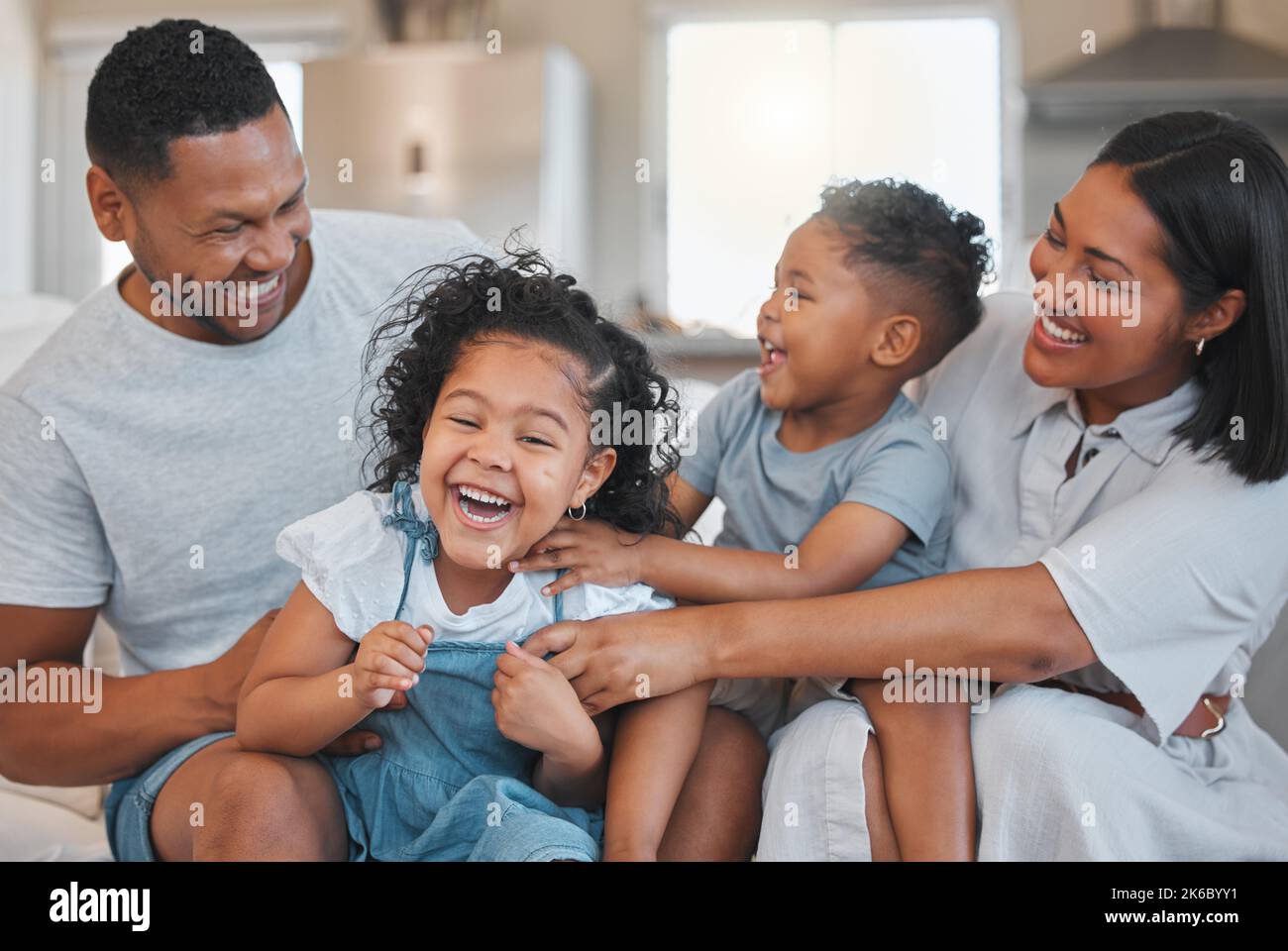Was ist Geld ohne Glück. Eine junge Familie verbindet sich glücklich auf dem Sofa zu Hause. Stockfoto
