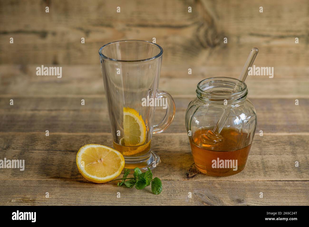 Honig und Zitrone auf einem Holztischbereit, mit Wasser für ein beruhigendes Getränk gemischt werden. Stockfoto