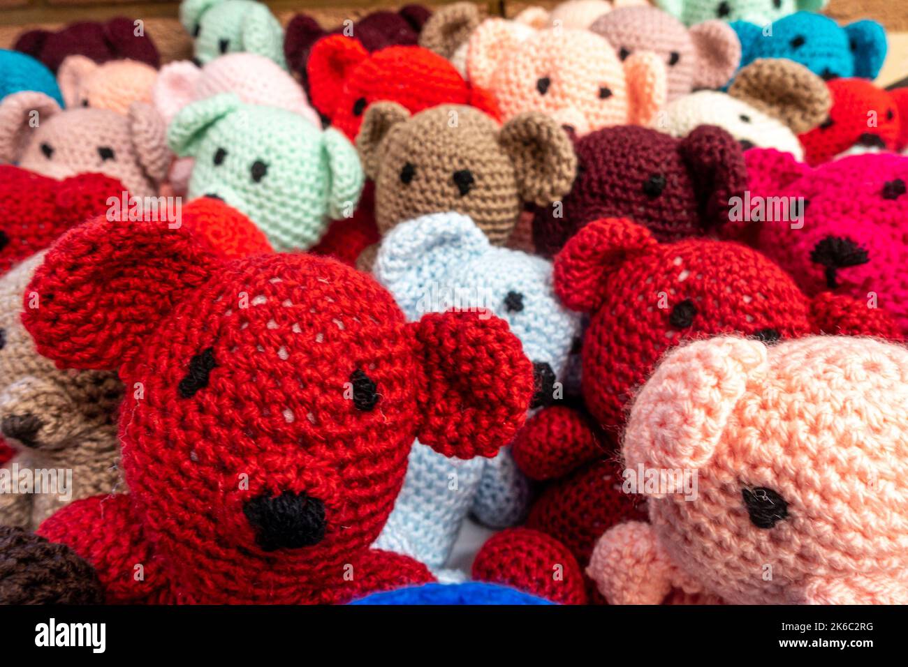 Gestrickte Teddybären in farbenfrohen Farben, die als Geschenke für Kinder erhältlich sind. Stockfoto