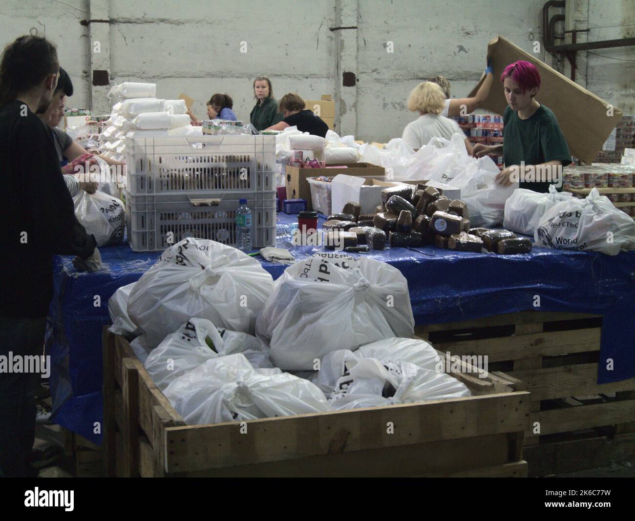 Lokale Freiwillige packen Lebensmittelpakete, die von der World Central Kitchen in der Stadt Tschernihiw, Ukraine, bereitgestellt werden Stockfoto