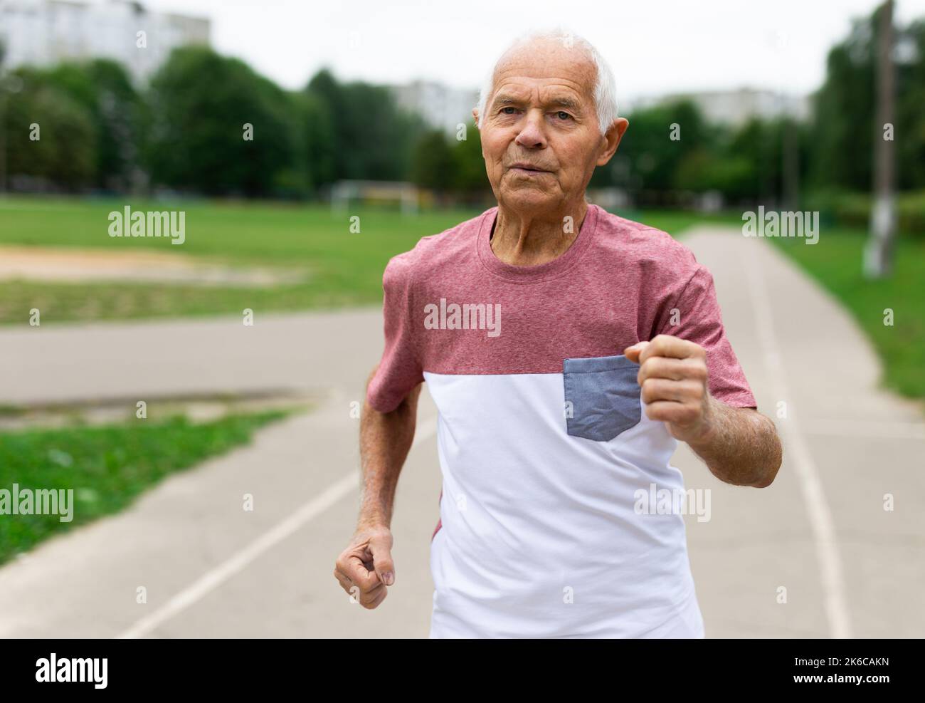 Aktiver Senior joggt im Sommerpark. Gesunder Lebensstil im Ruhestand Stockfoto