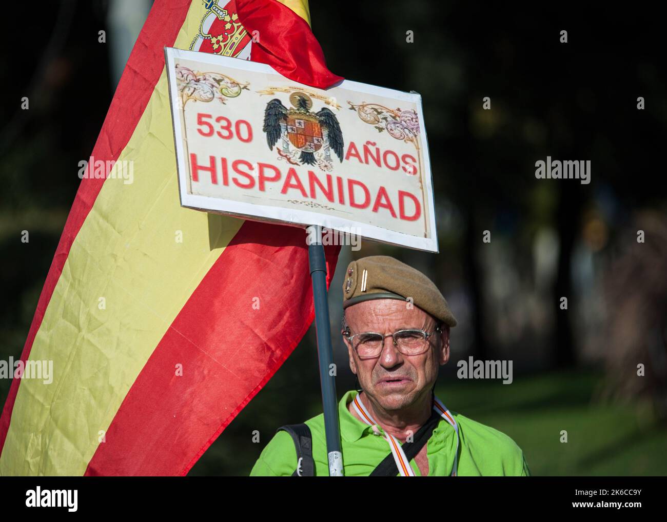 Barcelona, Spanien. 12. Oktober 2022. Ein nostalgischer älterer Mann hält während der Parade zum Hispanic Day eine spanische Flagge mit einem Plakat mit dem vorkonstitutionellen Adler. 12. Oktober, Nationalfeiertag Spaniens. Der Ursprung dieses Feiertages geht auf das 15.. Jahrhundert zurück, als am 12. Dezember 1492 Christopher Columbus und seine Besatzung an der Küste von Guanahani (Bahamas) landeten. Kolumbus dachte, er hätte die Indien erreicht, aber in Wirklichkeit entdeckte er den neuen Kontinent, Amerika. Dieses Datum ist die Erhöhung des spanischen Nationalismus. (Foto: Mario Coll/SOPA Images/Sipa USA) Quelle: SIPA USA/Alamy Live News Stockfoto