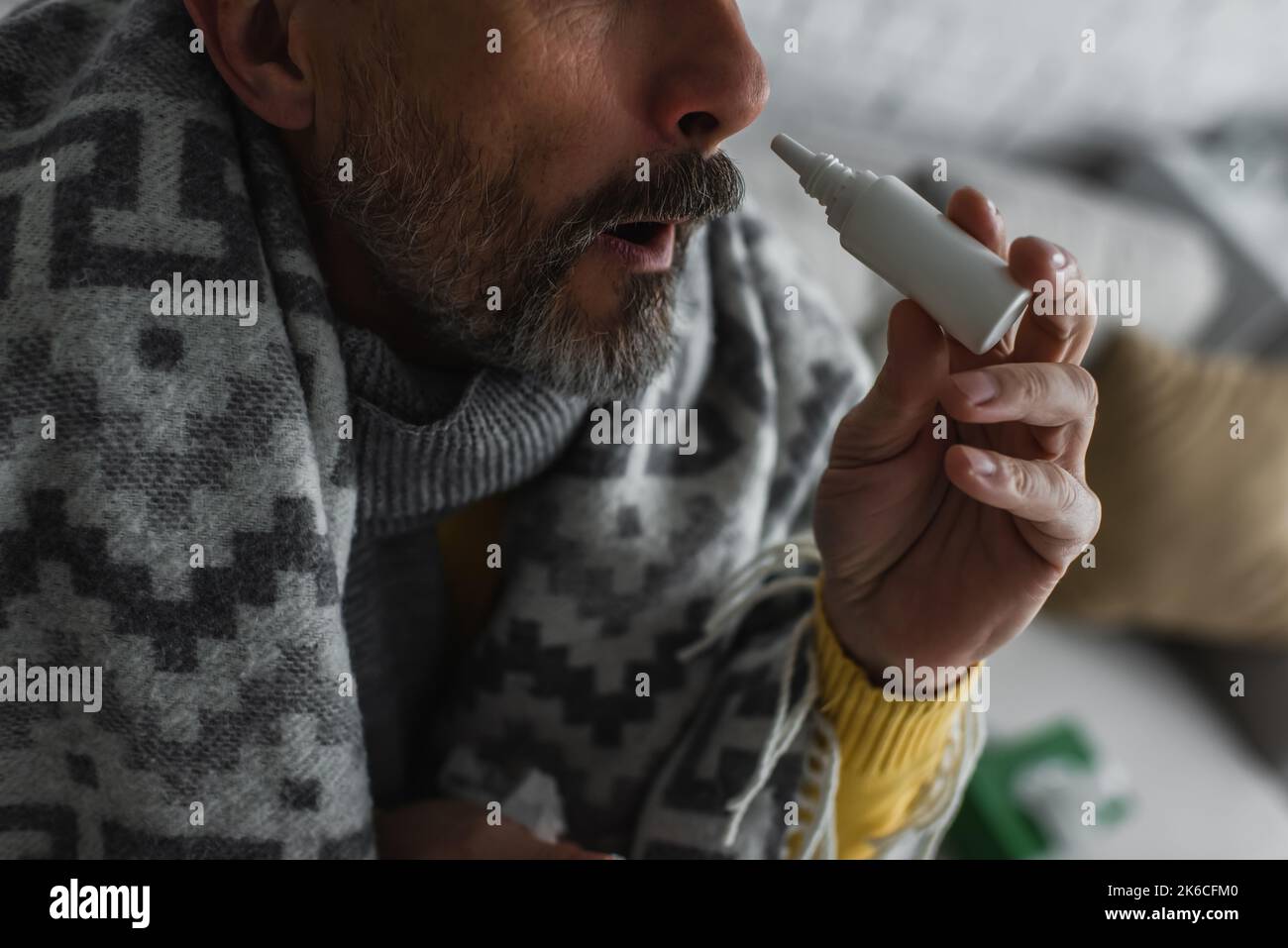 Beschnittene Ansicht eines kranken Mannes mit Rhinitis mit Nasenspray, Stockbild Stockfoto