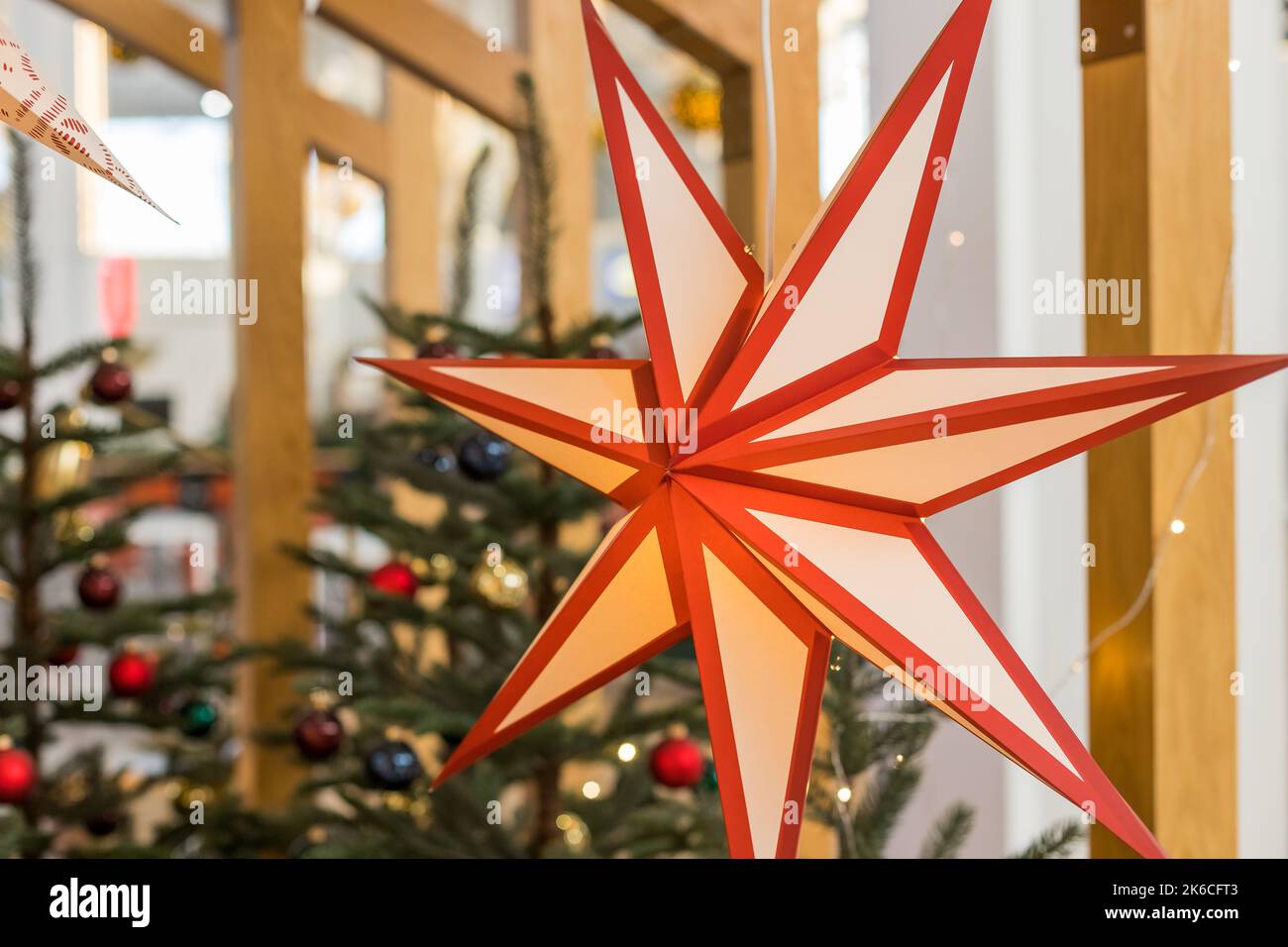 Ein Weihnachtsstern im Fenster. Warmes Licht, Weihnachten, gemütliche Atmosphäre. Adventszeit.Papierblitzlaterne in Sternform. Neujahr Dekoration Stockfoto
