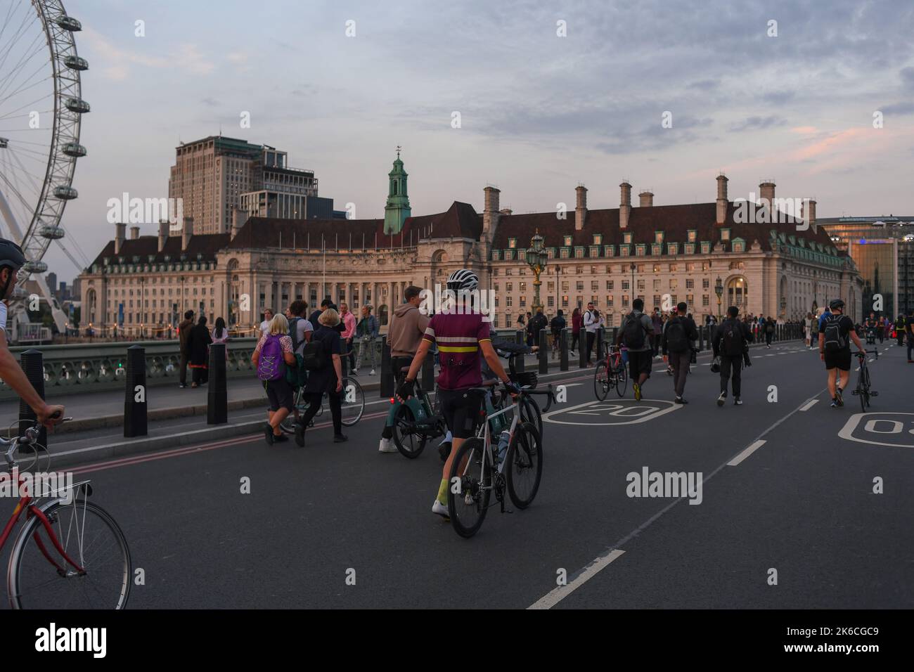 Massen von Menschen gehen auf der Straße über die Westminster Bridge und nutzen die Straßensperrung, da Queen bei der Staatszeremonie liegt. Stockfoto