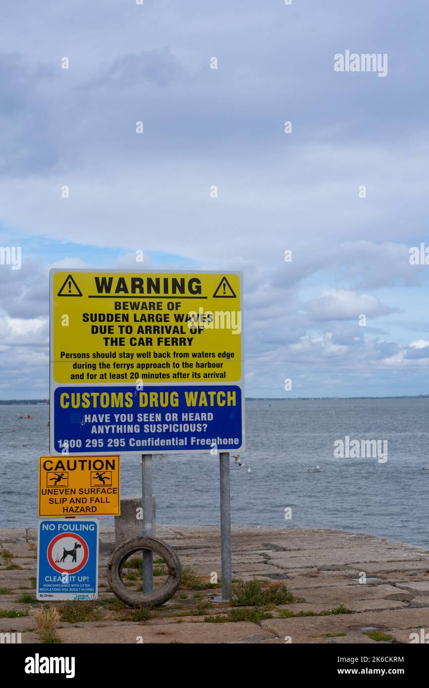 Warnschilder über plötzliche große Wellen, Gepflochs-Beobachtung, Risiko von Ausrutschen und Stürzen und Hundefouling im Bulloch Harbour Dalkey in der Nähe von Dublin Ireland Stockfoto