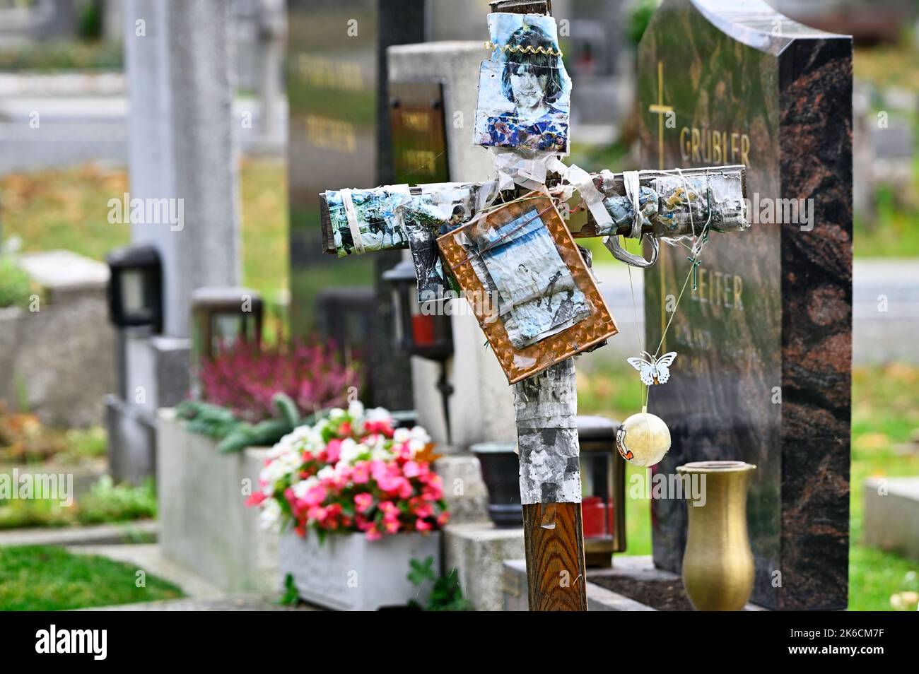 Wien, Österreich. Der Wiener Zentralfriedhof. Holzkreuz mit Fotografien Stockfoto