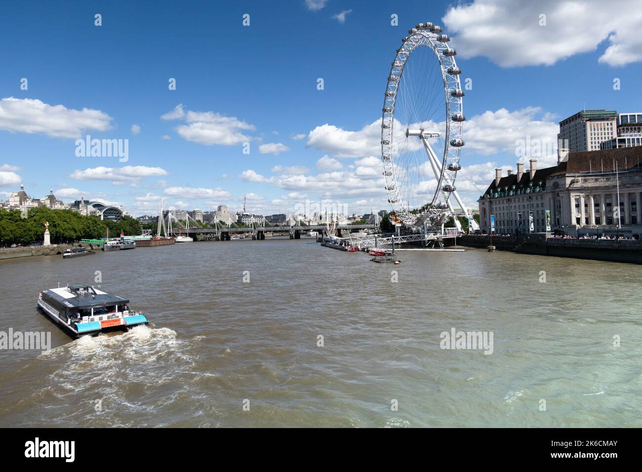 Blick auf die themse mit einem Flusskreuzfahrtschiff und dem London Eye Stockfoto