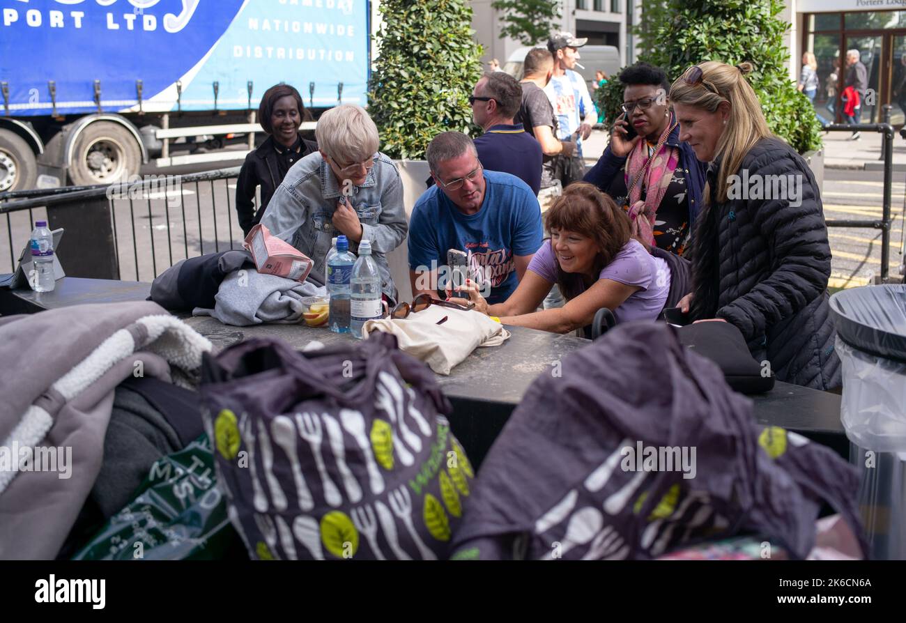 Am ersten Tag, an dem die Queen im Staat in der Westminster Hall liegt, stehen Mitglieder der Öffentlichkeit in der Schlange an der South Bank London UK.viele sehen sich telefonisch an. Stockfoto