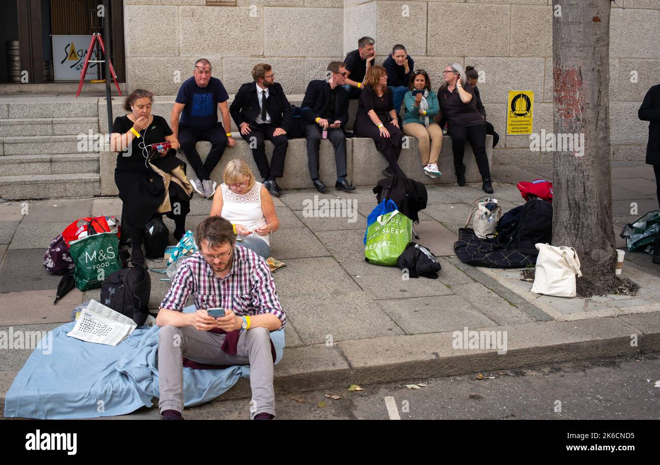 Am ersten Tag, an dem die Queen im Staat in der Westminster Hall liegt, stehen Mitglieder der Öffentlichkeit in der Schlange an der South Bank London UK.viele sehen sich telefonisch an. Stockfoto