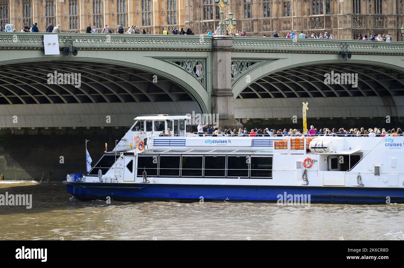City Cruises Boot fährt unter der Westminster Bridge London UK voller Passagiere auf dem offenen Deck. Stockfoto