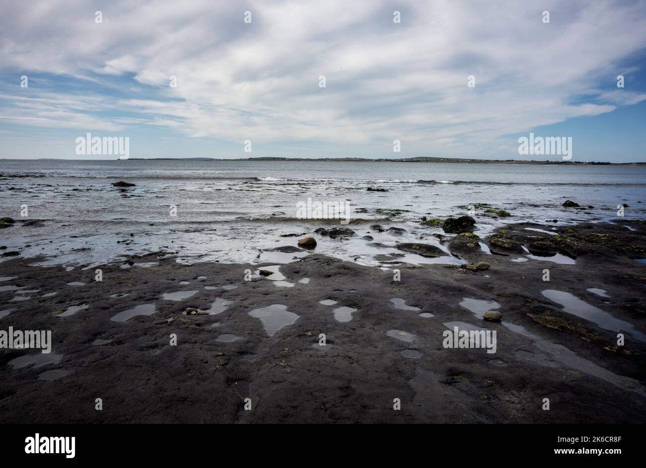 Ein Sturm hat fast den ganzen Sand an einem Strand in co. Weggespült Mayo, Irland. Wo der Sand weggespült wurde, ist jetzt nur noch schwarzer Torf übrig. Stockfoto