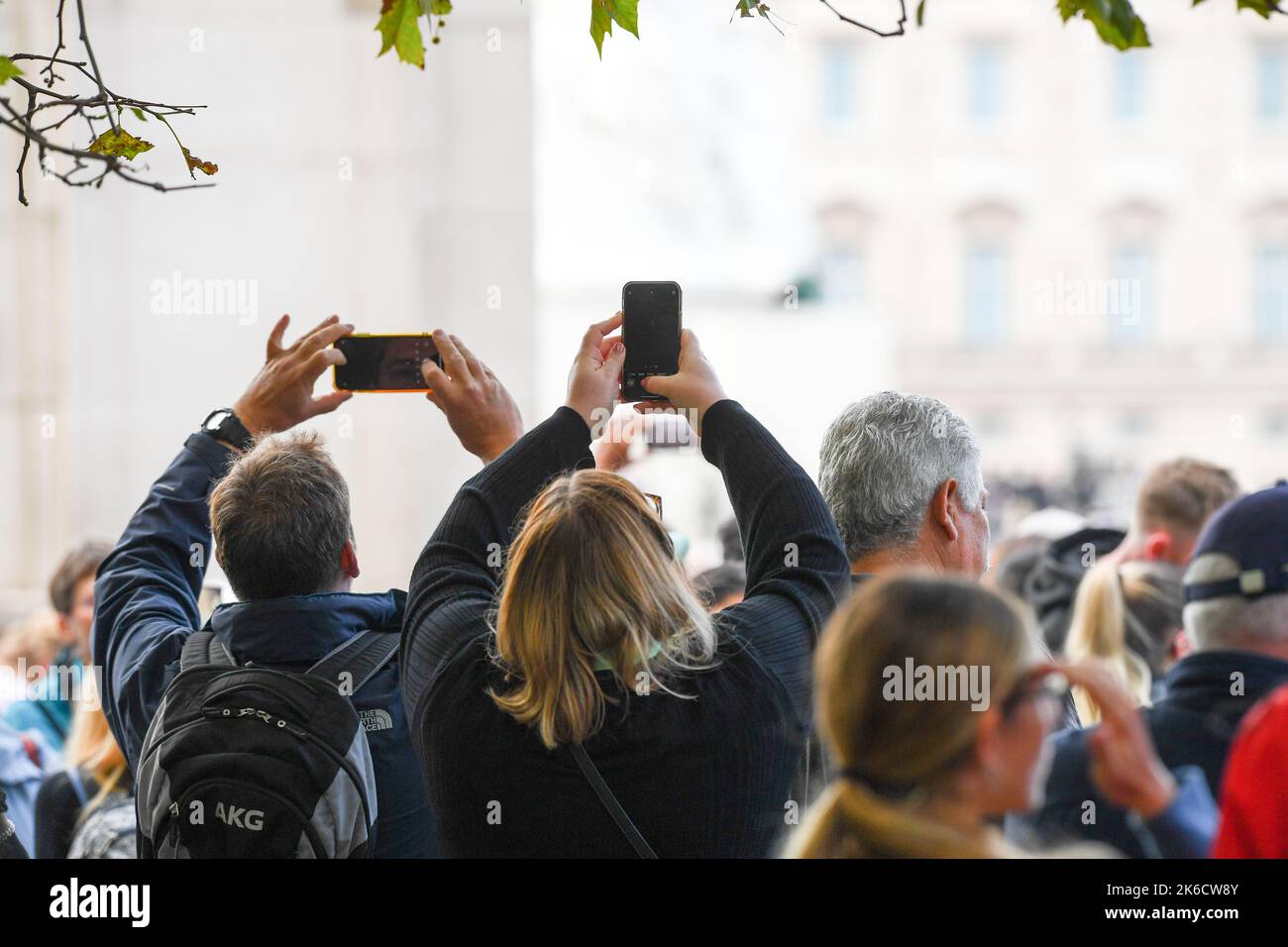 Mitglieder der Öffentlichkeit nehmen Bilder auf ihren Mobiltelefonen auf, während sie darauf warten, dass der Queens Coffin die Mall in Richtung Westminster Hall gebracht wird. Stockfoto