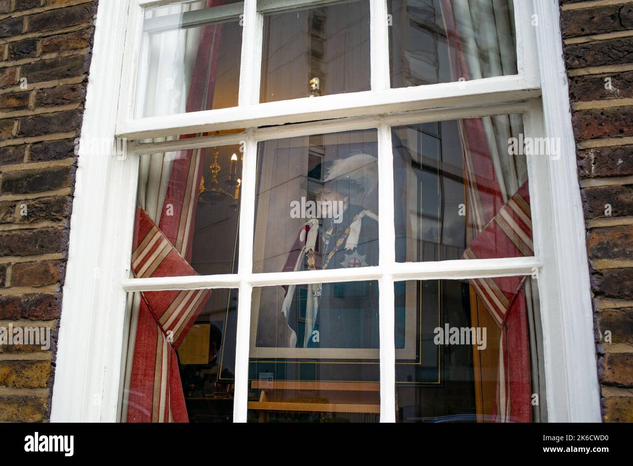 Ein Porträt der Königin, das am ersten Tag der Königin in einem Schaufenster in der Londoner Princess Street gezeigt wird, liegt im State at Westminster Palace. Stockfoto