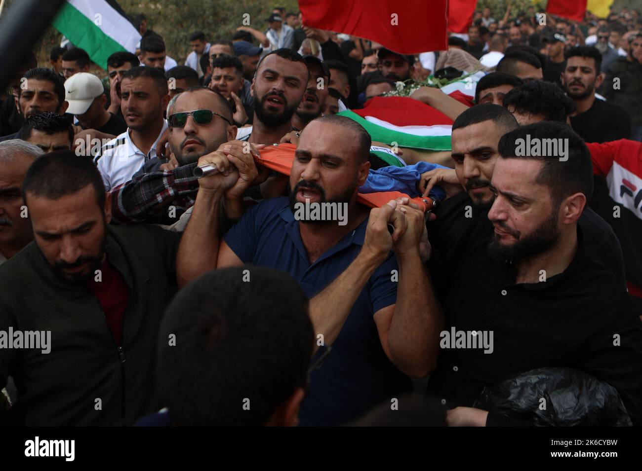 (221013) -- HEBRON, 13. Oktober 2022 (Xinhua) -- Trauernde tragen den Leichnam von Osama Adawi, der von einem israelischen Soldaten während seiner Beerdigung in der Stadt Hebron im Westjordanland am 13. Oktober 2022 getötet wurde. Ein Palästinenser wurde am Mittwoch bei Zusammenstößen mit israelischen Soldaten im Al-Aroub Flüchtlingslager nördlich der Stadt Hebron im südlichen Westjordanland getötet und drei weitere verletzt, sagten palästinensische Gesundheitsbehörden und Augenzeugen. Das palästinensische Gesundheitsministerium erklärte in einer Erklärung, dass Osama Adawi, 18, getötet wurde, nachdem er von einem israelischen Soldaten während der Zusammenstöße am Nachmittag, Addin, angeschossen wurde Stockfoto