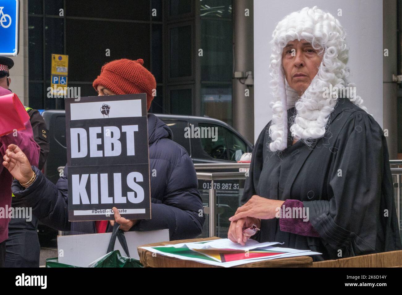 London, Großbritannien. 13 Okt 2022. Der Richter auf ihrer Bank. In einem internationalen Aufruf zu Klimagerechtigkeit und Beendigung der Schuldenzahlungen forderten die Demonstranten in Londons Büros der Weltbank. Sie versuchen den Präsidenten der Bank, D R Malpas (ernannt von Trump) Mit Zeugen aus Ländern auf der ganzen Welt über die katastrophalen Auswirkungen der Bank, einschließlich Rückzahlungen, die den globalen Süden zwingen, riesige Ressourcen an die Reichen zu übertragen, während sie enorme Kosten des Klimawandels tragen, haben sie sehr wenig bewirkt. Peter Marshall/Alamy Live News Stockfoto