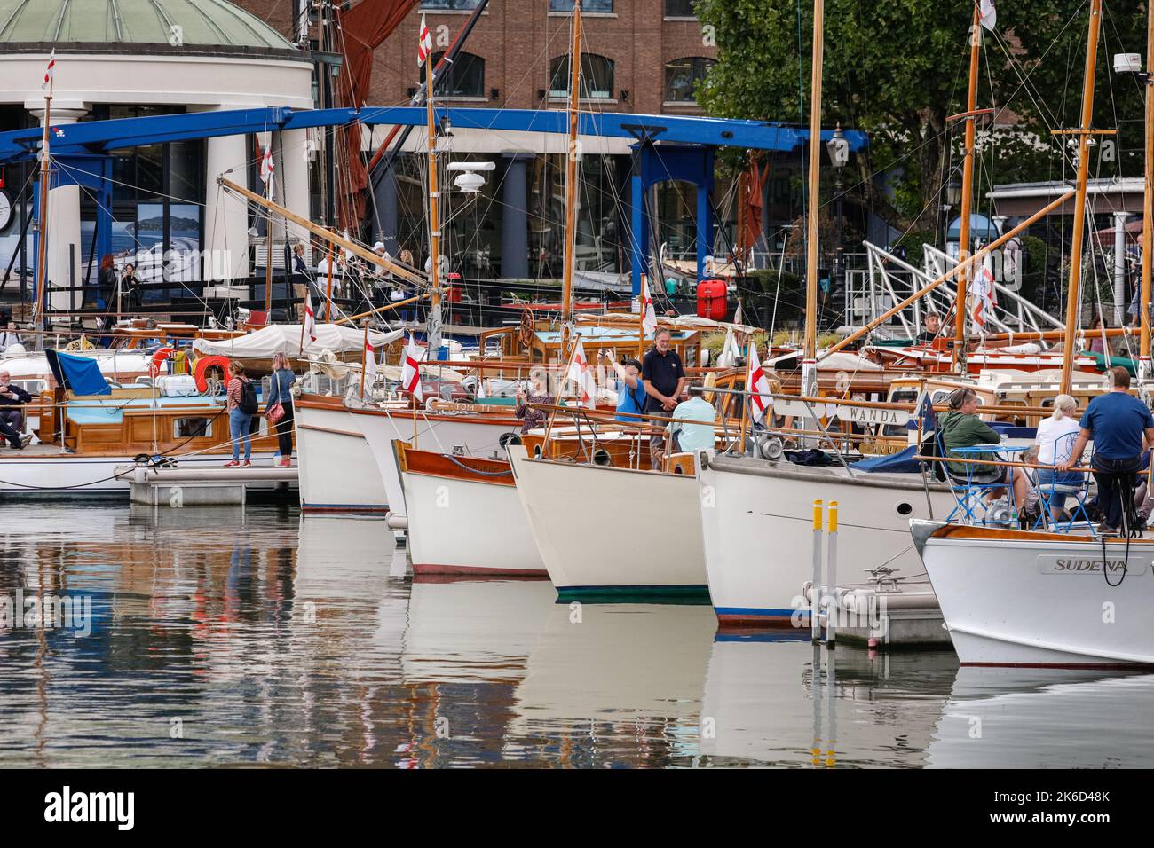 Beim St. Katherine Docks Classic Boat Festival, London, England, sitzen Menschen auf ihren alten Booten und Yachten Stockfoto