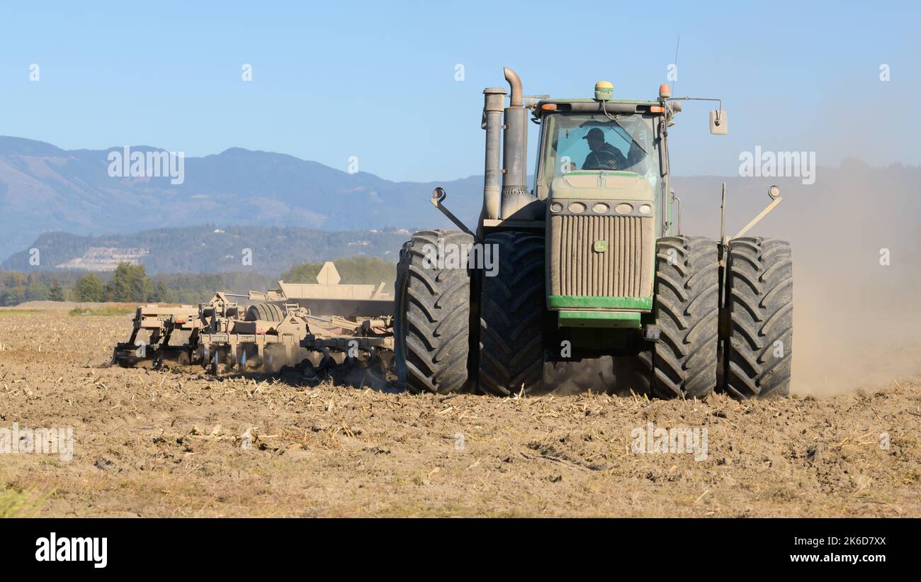 Skagit Valley, WA, USA – 11. Oktober 2022; John Deere 9530 Knickgelenkter 4WD-Traktor, der im Herbst mit einer Scheibenegge in einem Trockenpflanzenfeld arbeitet Stockfoto