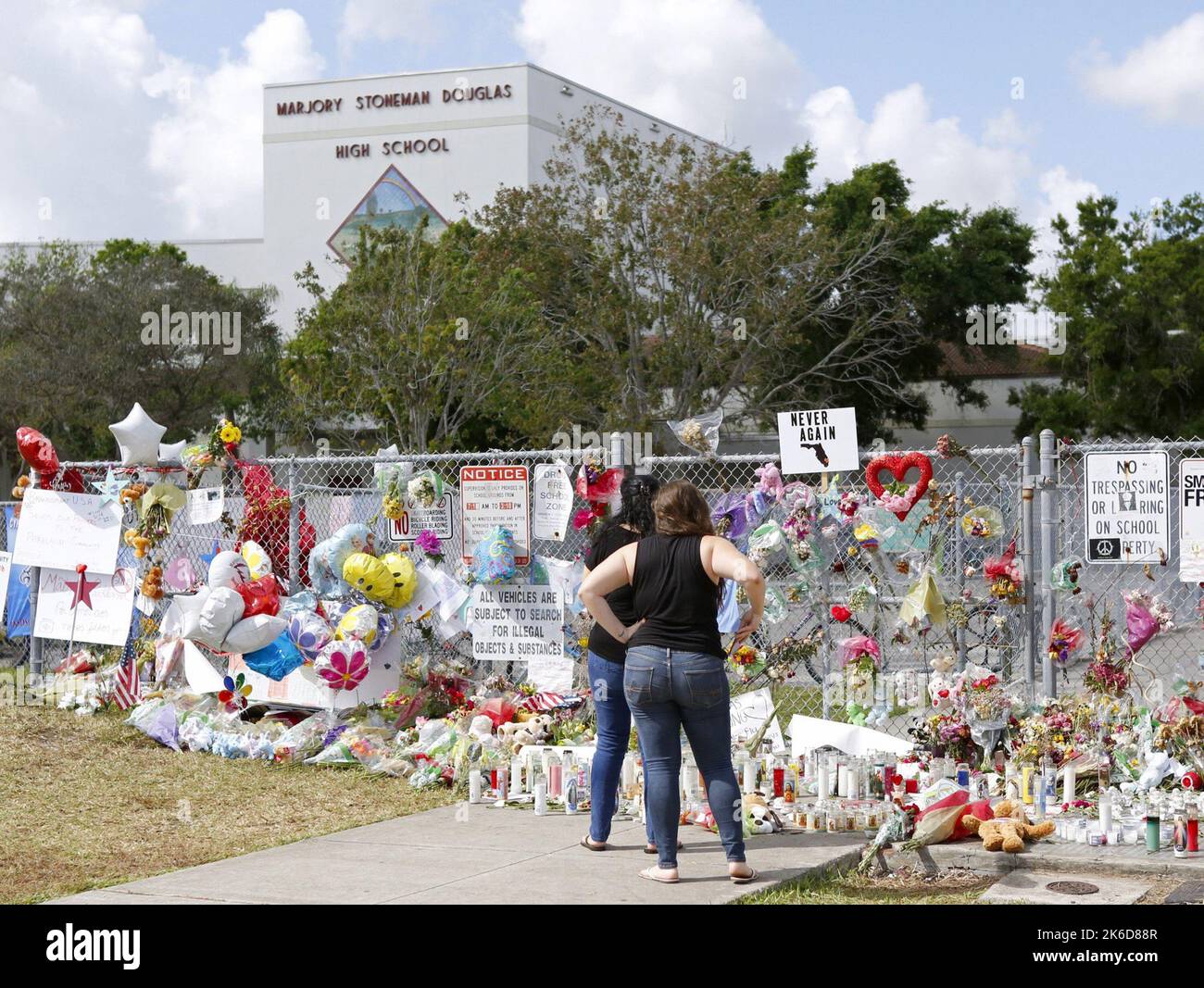 Parkland, USA. 24.. Februar 2018. Trauernde bringen Blumen, während sie an einem Denkmal für die Opfer der Erschießung am Sonntag, den 25. Februar 2018, an der Marjory Stoneman Douglas High School Tribut zollen. Für ein offenes Haus kehrten Eltern und Schüler zum ersten Mal in die Schule zurück, da siebzehn Opfer am 14. Februar bei einer Massenschießerei in der Schule in Parkland getötet wurden. (Foto von David Santiago/Miami Herald/TNS/Sipa USA) Quelle: SIPA USA/Alamy Live News Stockfoto