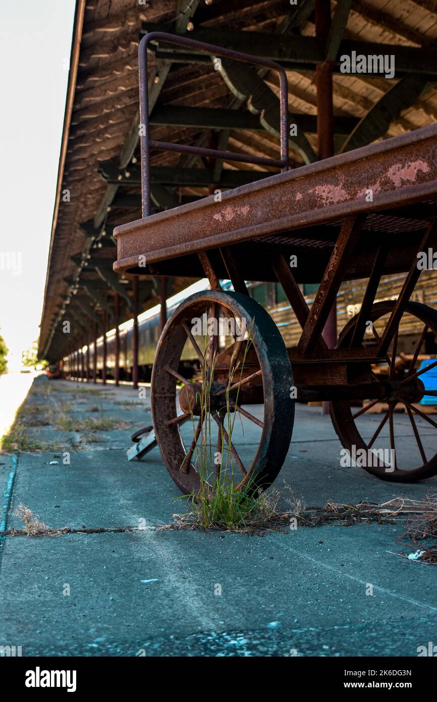 Eine vertikale Aufnahme eines alten rostigen Wagens am Bahnhof. Stockfoto