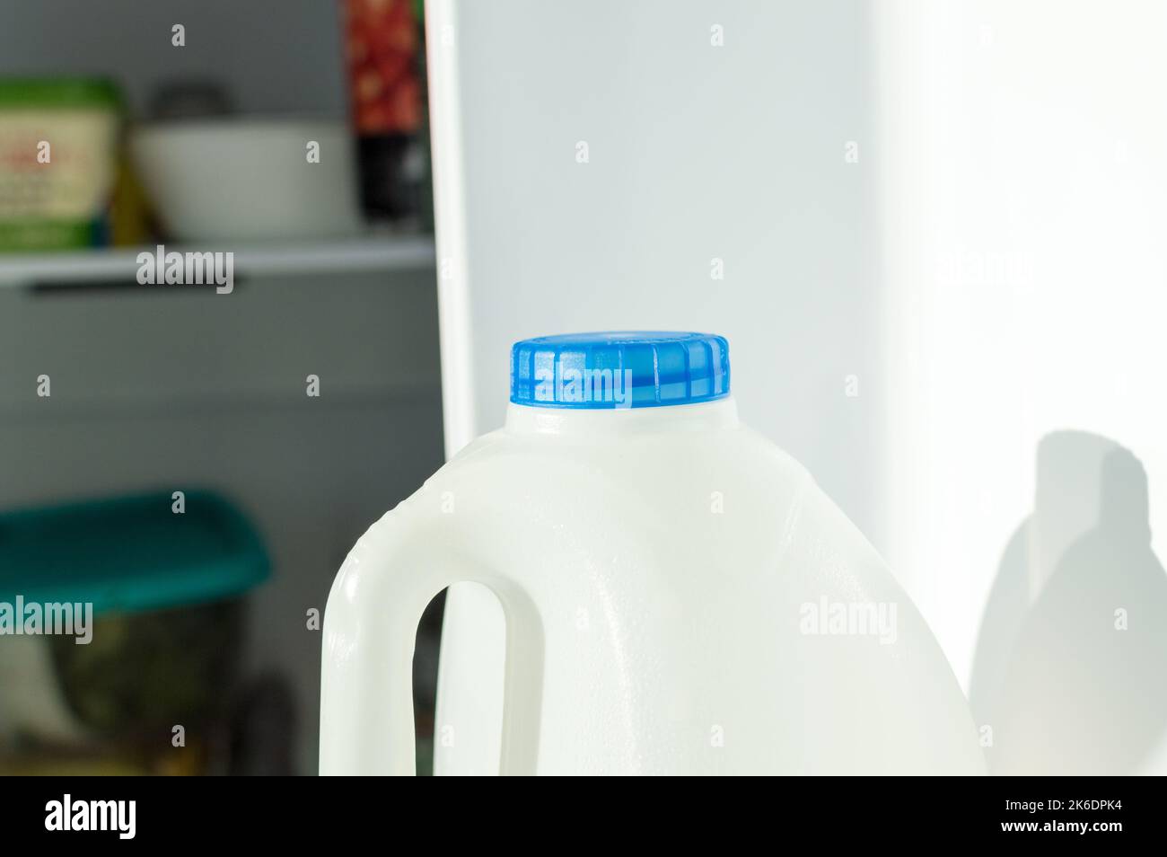 Milchflasche mit blauem Deckel im Kühlschrank Stockfoto