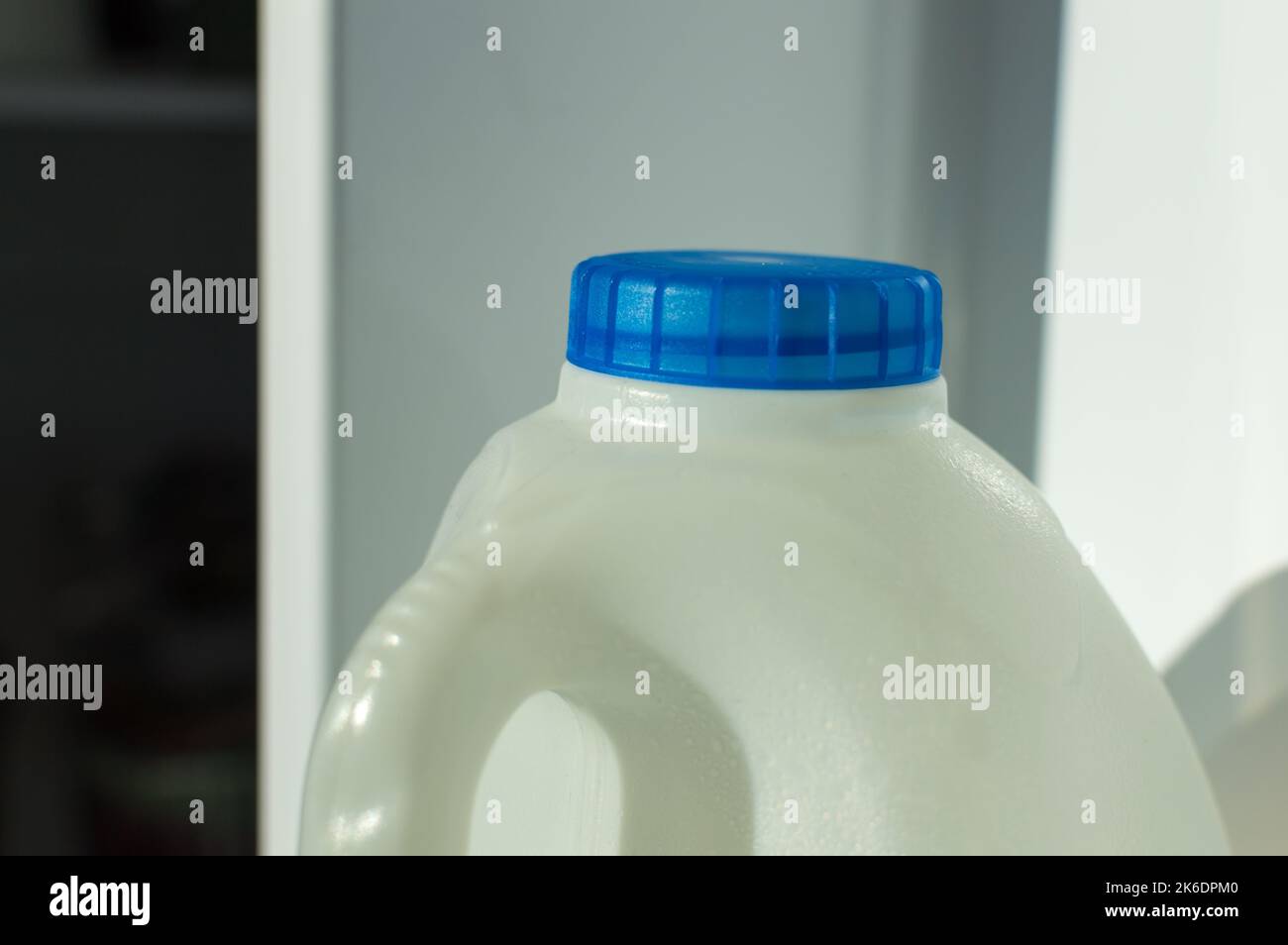 Milchflasche mit blauem Deckel im Kühlschrank Stockfoto
