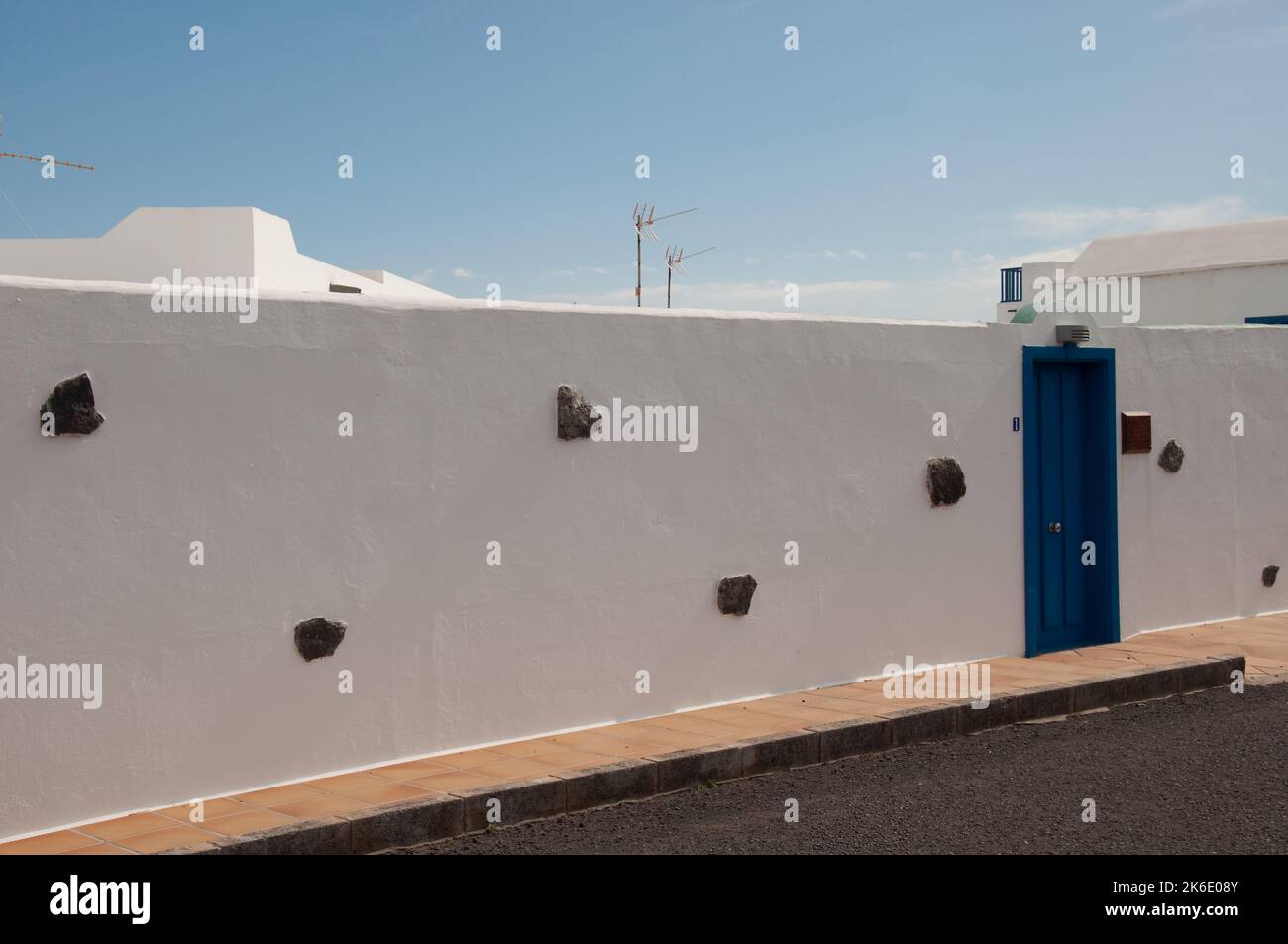 Wall, Punta Mujeres, Lanzarote, Kanarische Inseln. Außenwand und weiße Gebäude mit blauer Tür Stockfoto