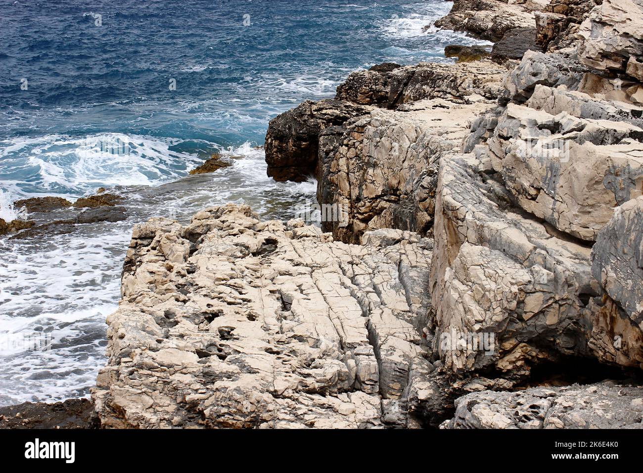 Küstenfelsen, die von Meereswellen bespritzt werden Stockfoto