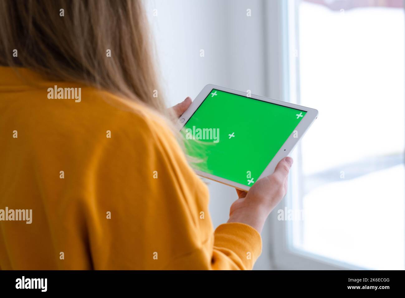 Mädchen mit iPad Tablet Anzeige grünen Bildschirm drücken Browsen Chroma-Taste online eingeben Text lesen Social Media close up Hände 13.12.21 St.Petersburg Stockfoto