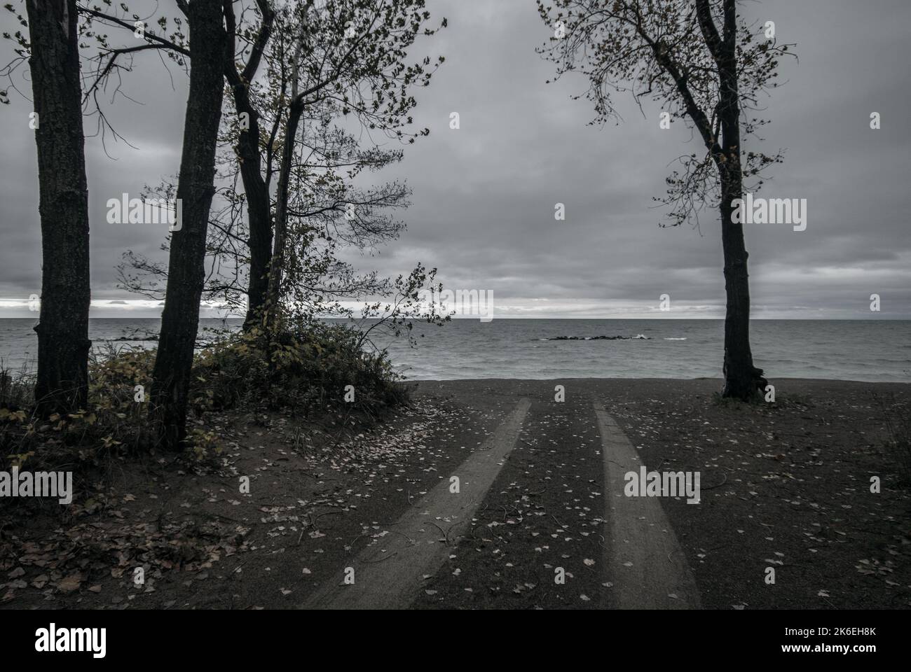 Reifenspuren, Ende der Straße, düstere, deprimierende Küstenlinie Stockfoto