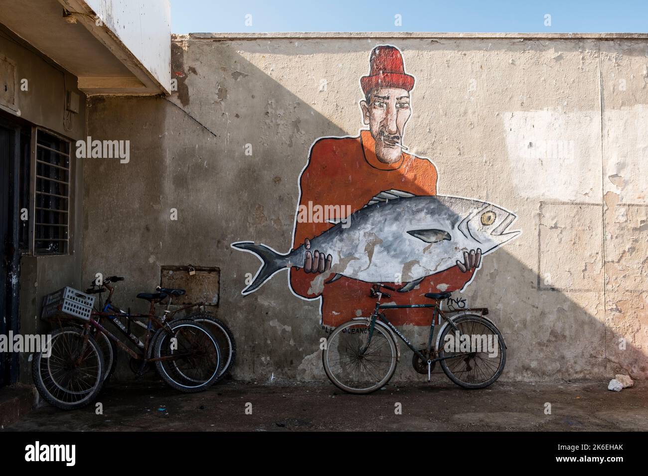 Wandkunst, die Fischer mit frisch gefangenem Fisch zeigt, der verkauft werden kann, Hafen von Essaouira, Marokko Stockfoto
