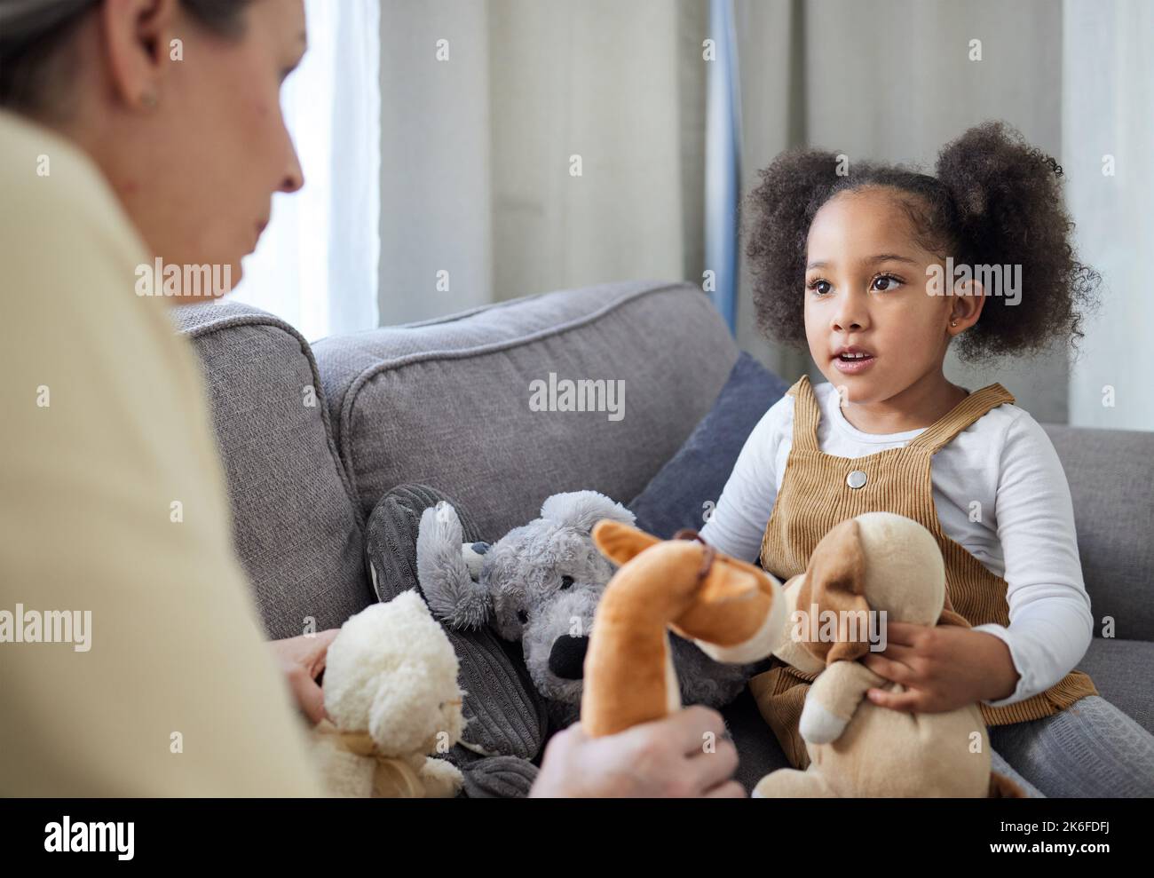 Eine frühe Entwicklung des Kindes kann Konsequenzen haben. Eine reife Therapeutin, die ihre junge Patientin ermutigt, mit Spielzeug zu spielen. Stockfoto