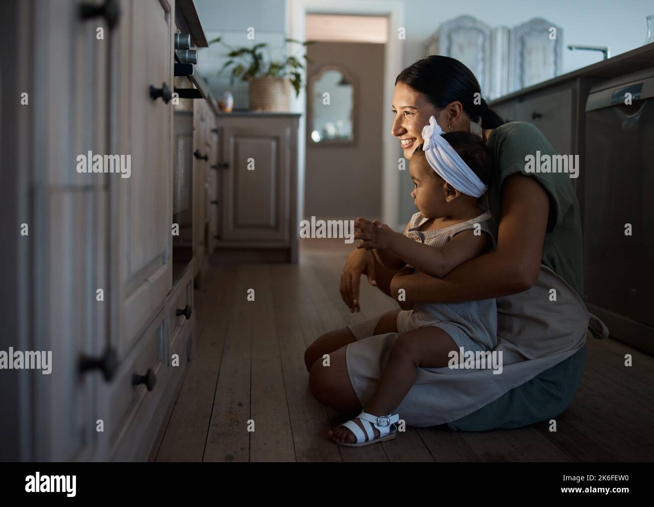 Wenn man kochen lernt, sagt nichts Geduld, wie beim Backen eines Kuchens zuzusehen. Nette Mutter und ihr neugieriges Mädchen Tochter beobachten einen Ofen. Kind und Stockfoto