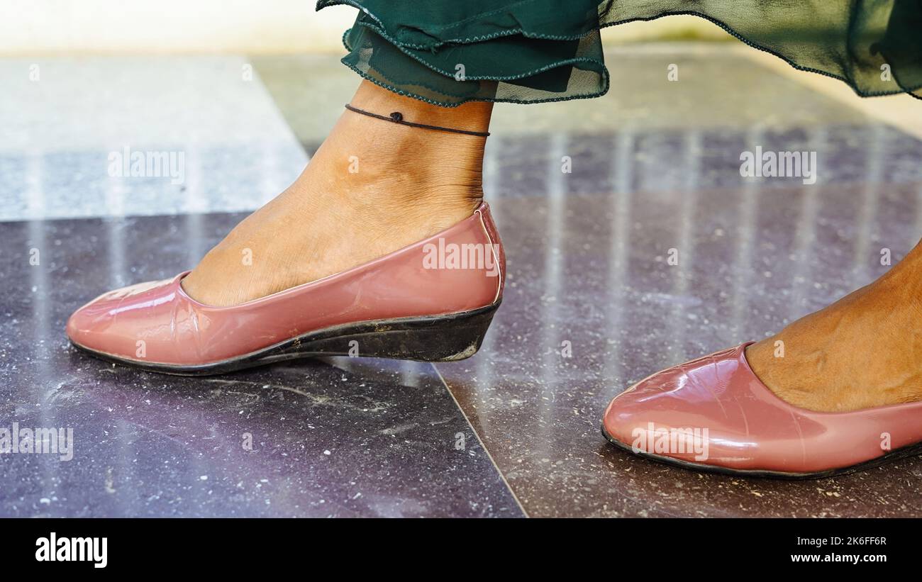 Nahaufnahme der weiblichen Beine einer Arbeiterin, die in der Nähe ihres Büros steht. Die junge Dame trägt formelle Kleidung und Schuhe auf hohen Absätzen. Stockfoto