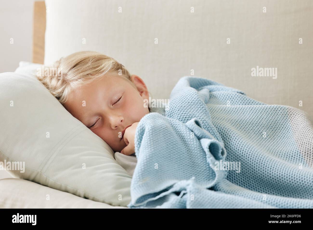 Schlafen Sie süß. Ein unwohl kleines Mädchen, das sich zu Hause auf dem Sofa ausruht. Stockfoto