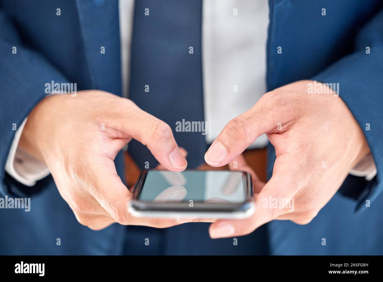 Die Welt in greifbarer Nähe. Ein nicht erkennbarer Geschäftsmann, der bei der Arbeit ein Telefon benutzt. Stockfoto