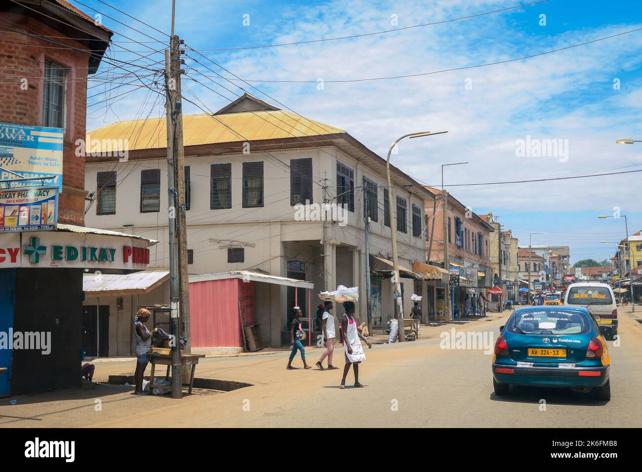 Kumasi, Ghana - 06. April 2022: Lokale ghanaische Menschen überqueren die überfüllte Afrikanische Straße in der Nähe des Marktes in Kumasi Stockfoto