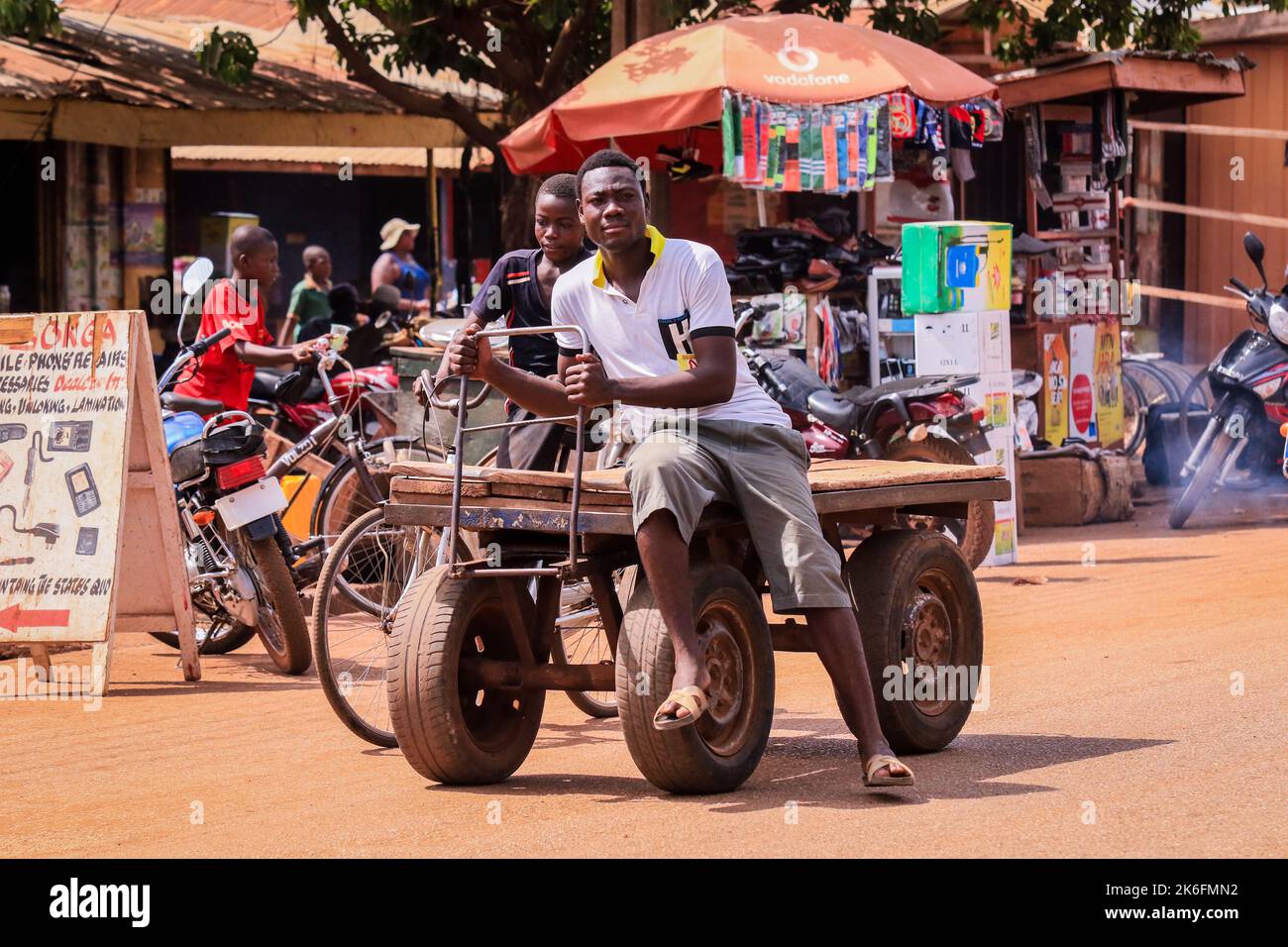 Tamale, Ghana - 07. April 2022: Afrikanische Straße mit Einheimischen Ghanas auf einem Fahrzeug in Tamale Stockfoto