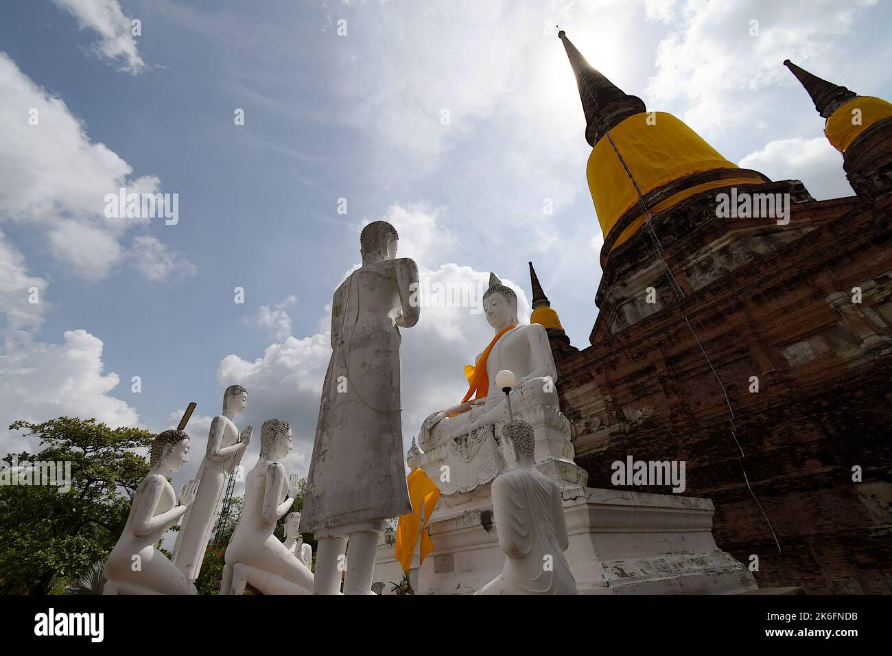 Steinskulpturen von Menschen, die dem Buddha Respekt zollen, in einer "erdberührenden" Pose, die hier am Fuß des Chedi im Wat Yai Chai Mongkhon, Ayutthaya, zu sehen ist Stockfoto