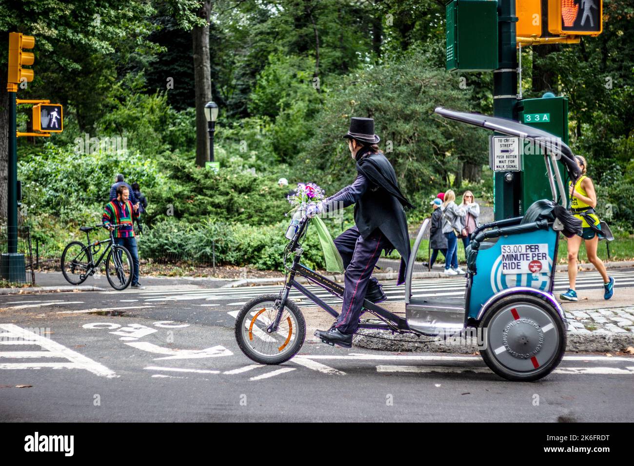 Central Park, New York City, USA, 13. Oktober 2018. Ein Rikscha-Reiter in Anzug und Zylinder fährt im Herbst durch den Central Park Stockfoto