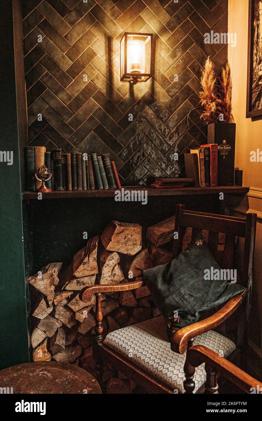 Rustikale Innenausstattung des Wohnzimmers mit Bücherregal und Kamin Stockfoto