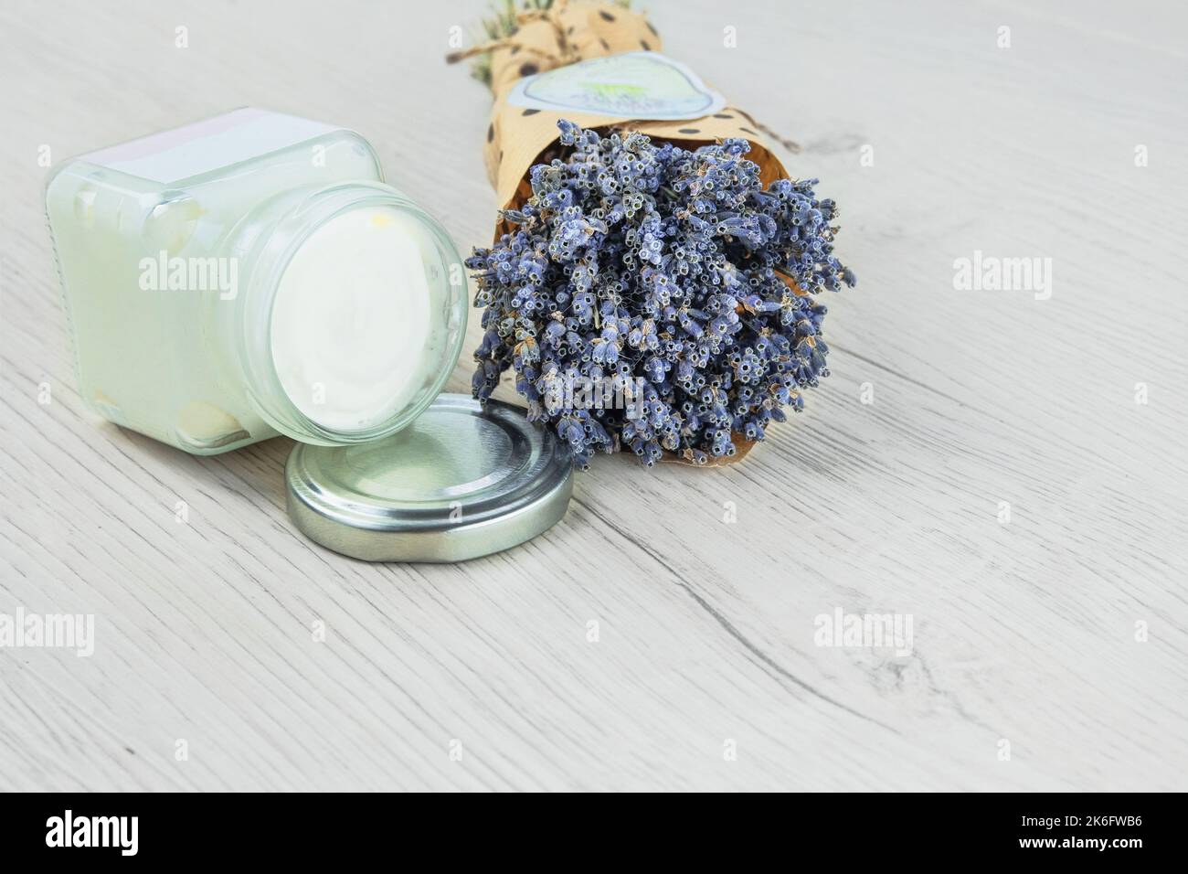 Natürliche handgemachte kosmetische Creme-Glas und getrocknete Lavendelblüten, heller Hintergrund. Bio-Bio-Kosmetik. Anlagenbasis. Stockfoto
